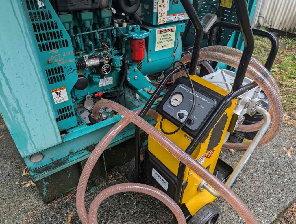 Portable fluid service pump connected to generator equipment with hoses and pressure gauge